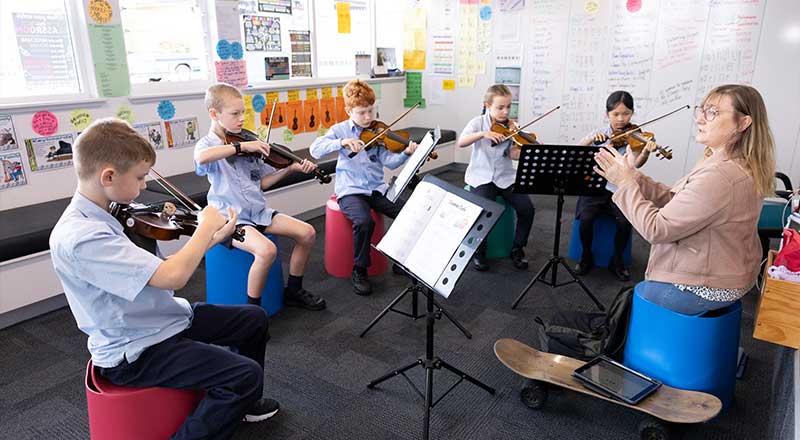 CSPD teacher leading St Canice’s Katoomba students in orchestra. The students are playing viola