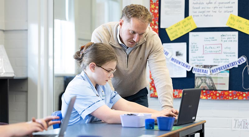 Teacher assisting St Canice's Katoomba student with laptop