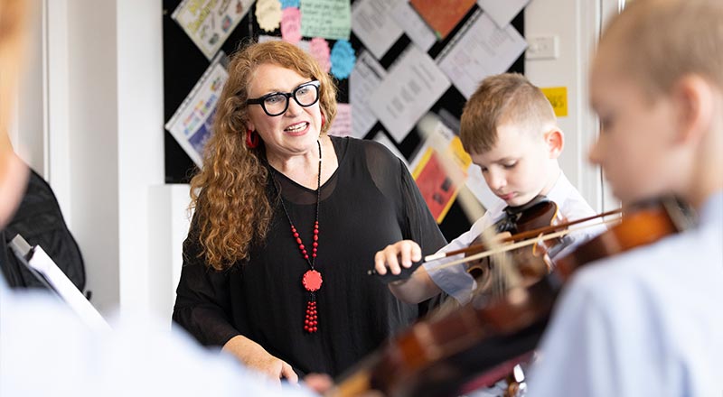 St Canice's Music Teacher assisting students in Ensemble