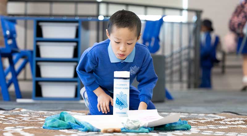 Faith and student lighting candle at St Canice's Catholic Primary Katoomba