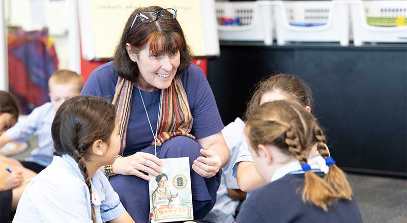 Teacher assisting St Canice’s Katoomba students in library