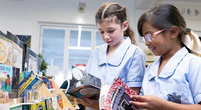 St Canice’s Katoomba students picking books from library shelf