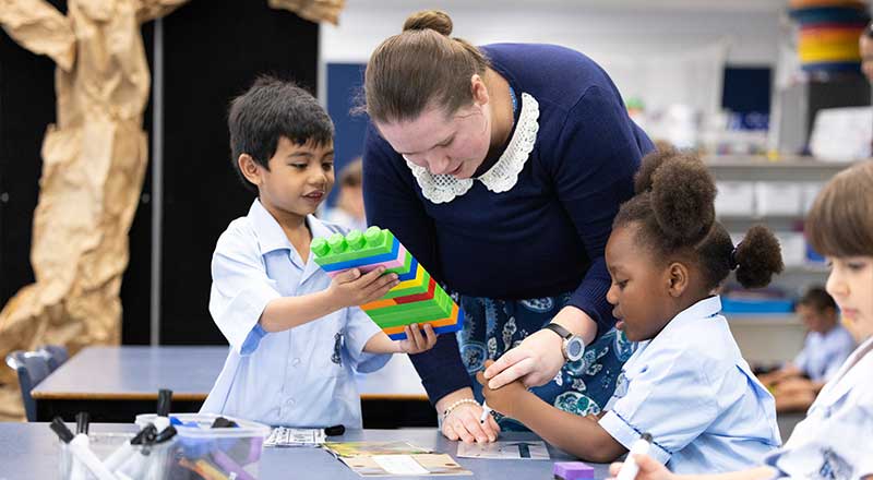 Teacher assisting students in class at St Canice’s Katoomba